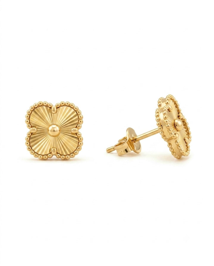 18 Karat Gold-Ohrstecker in Form eines vierblättrigen Kleeblatts mit feiner Sonnenstrahlgravur, filigranem Perlenrand und polierter Mittelkugel. Die Aufnahme zeigt die Vorderseite sowie die Seitenansicht mit klassischem Steckverschluss und hochwertiger Verarbeitung. Eleganter Goldschmuck für Alltag und besondere Anlässe, freigestellt auf weissem Hintergrund.