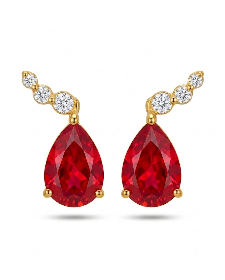 Detailaufnahme von Ohrsteckern aus 18k Gelbgold mit rotem Tropfenstein und weissen Zirkonia