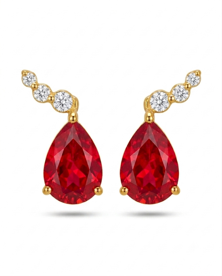 Detailaufnahme von Ohrsteckern aus 18k Gelbgold mit rotem Tropfenstein und weissen Zirkonia