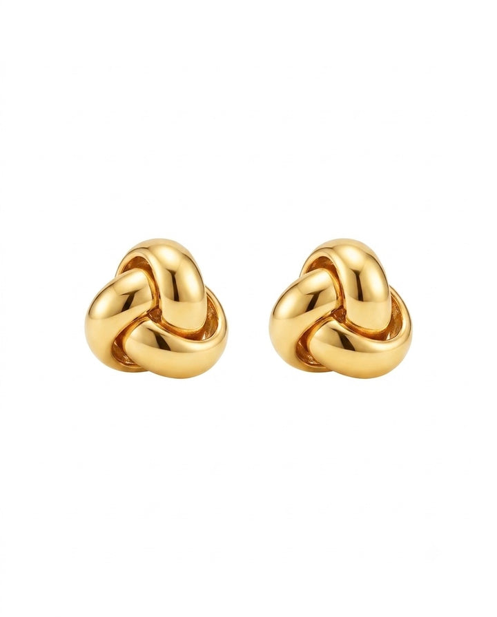 Detailaufnahme eines 18k Gelbgold-Ohrsteckers in Knotenform, weich gerundet und hochglanzpoliert, freigestellt auf hellem Hintergrund