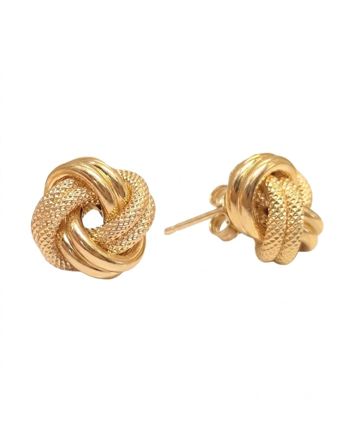 18 Karat Gelbgold-Ohrstecker in kunstvoller Knotenform mit strukturierter und hochglanzpolierter Oberfläche. Eleganter Goldschmuck mit Butterfly-Verschluss, inspiriert von der Symbolik eines unendlichen Knotens für Verbundenheit, Stärke und Beständigkeit.