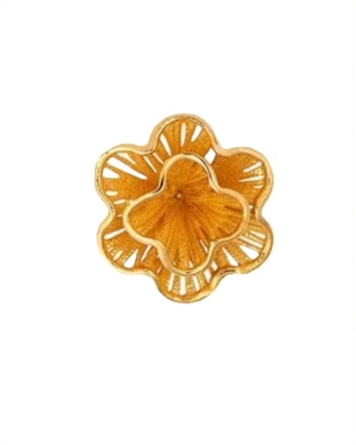 Nahaufnahme eines goldenen Blüten-Ohrsteckers mit Ornamentstruktur.