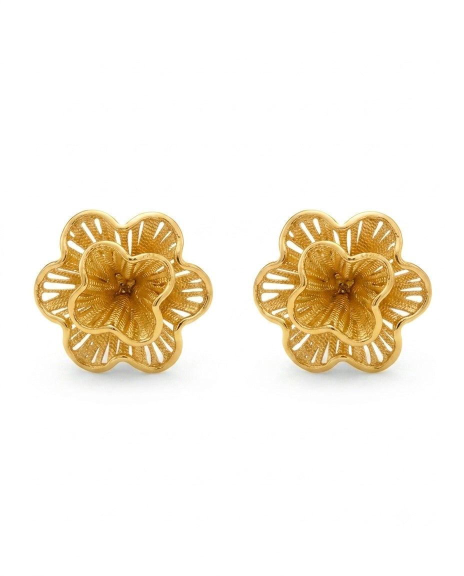 Nahaufnahme eines goldenen Blüten-Ohrsteckers mit Ornamentstruktur.