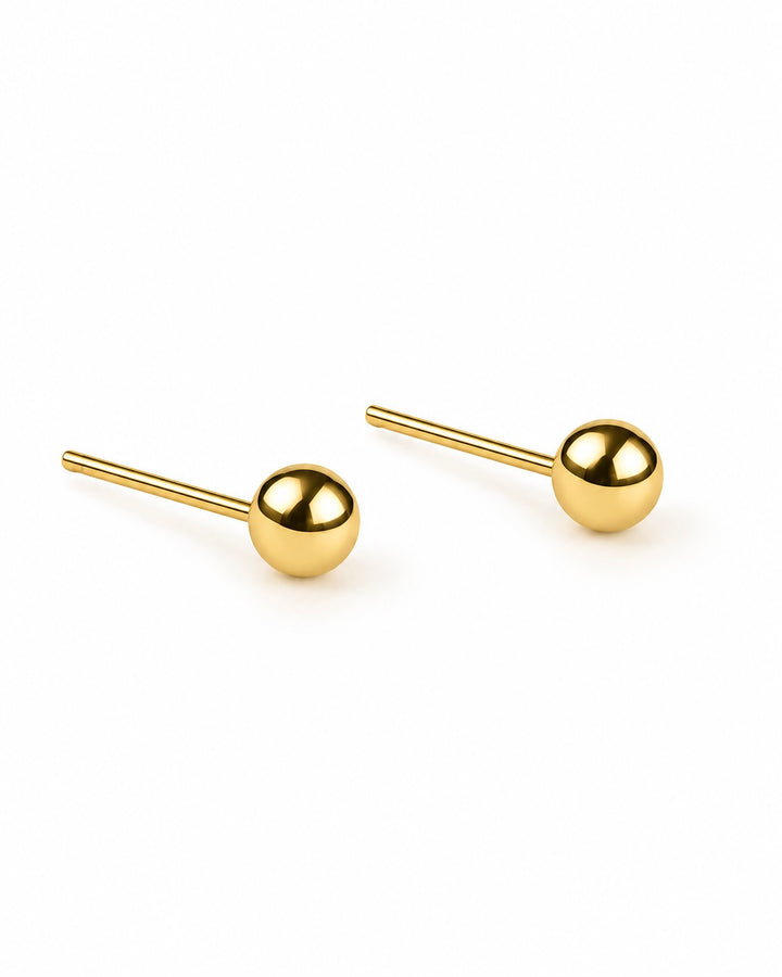 Goldene Kugel-Ohrstecker aus 18 Karat Gold mit glatter, glänzender Oberfläche auf weissem Hintergrund.