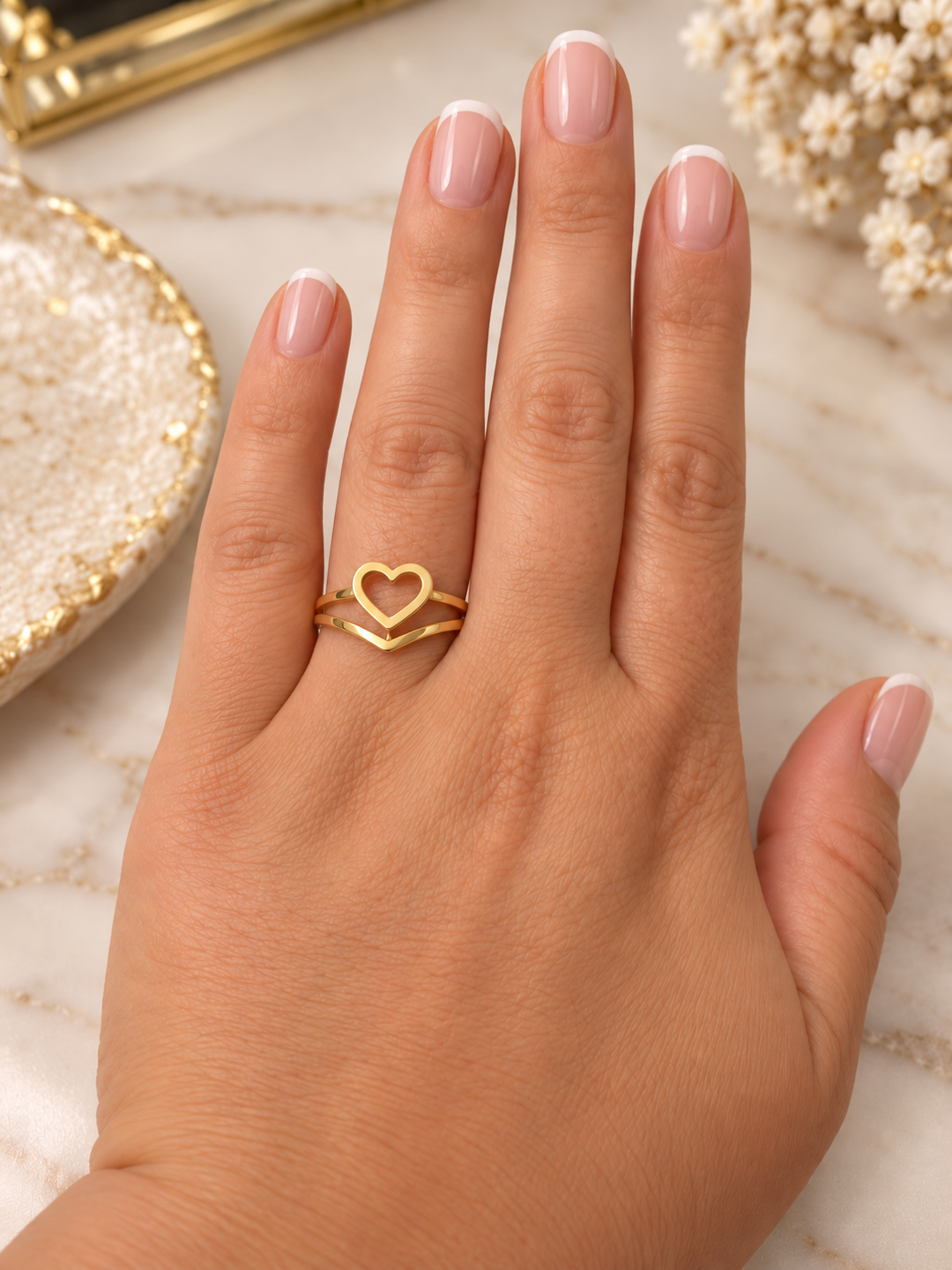 Goldring Peyvand mit offenem Herzmotiv an der Hand getragen, elegantes Design aus 18 Karat Gelbgold.