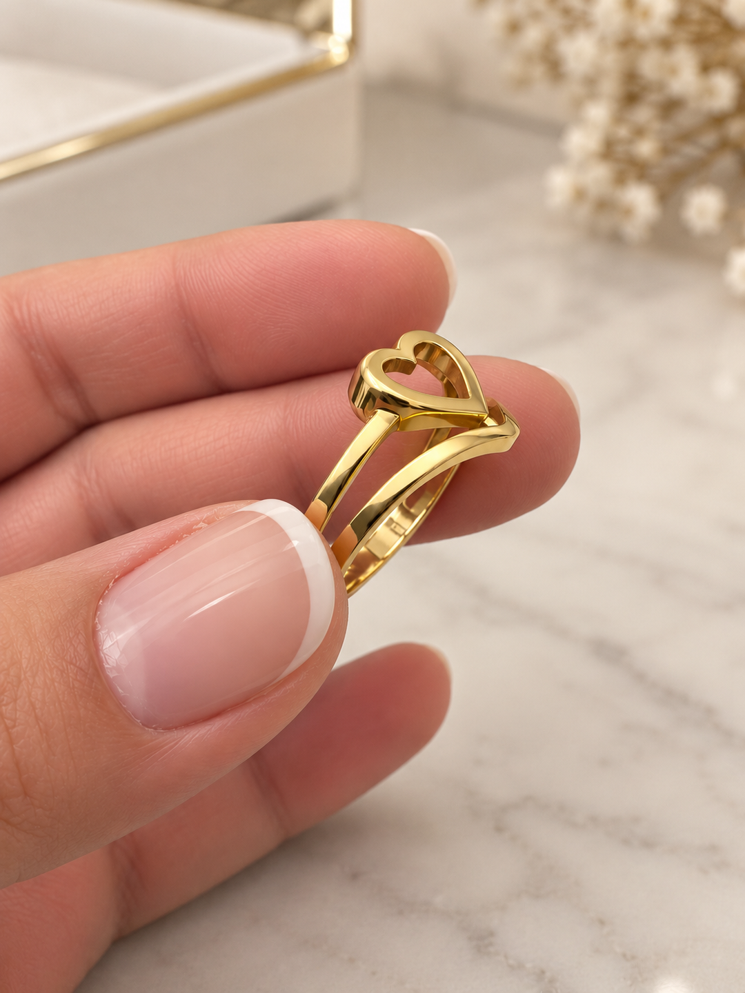 Detailansicht des Peyvand Goldrings mit erhabenem Herzmotiv, offener Ringschiene und glänzender Goldoberfläche.