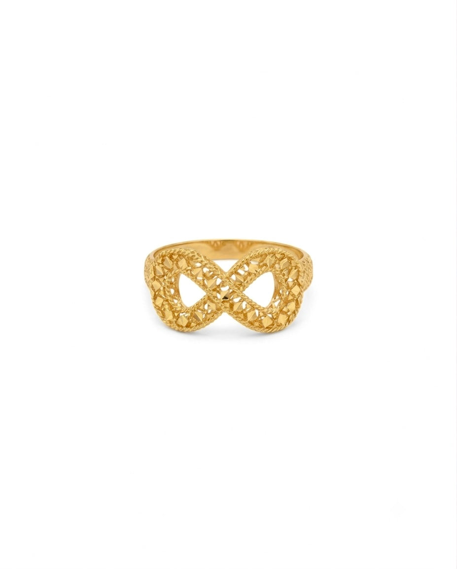 Ring aus 18 Karat Gelbgold mit kunstvoller, durchbrochener Flechtstruktur. Das Design bildet eine elegante Unendlichkeitsform (∞) mit filigranen, diamantierten Oberflächen, die das Licht aus verschiedenen Winkeln reflektieren. Der Ring vereint moderne Eleganz mit traditioneller Goldschmiedekunst und wirkt zugleich leicht, luftig und luxuriös.