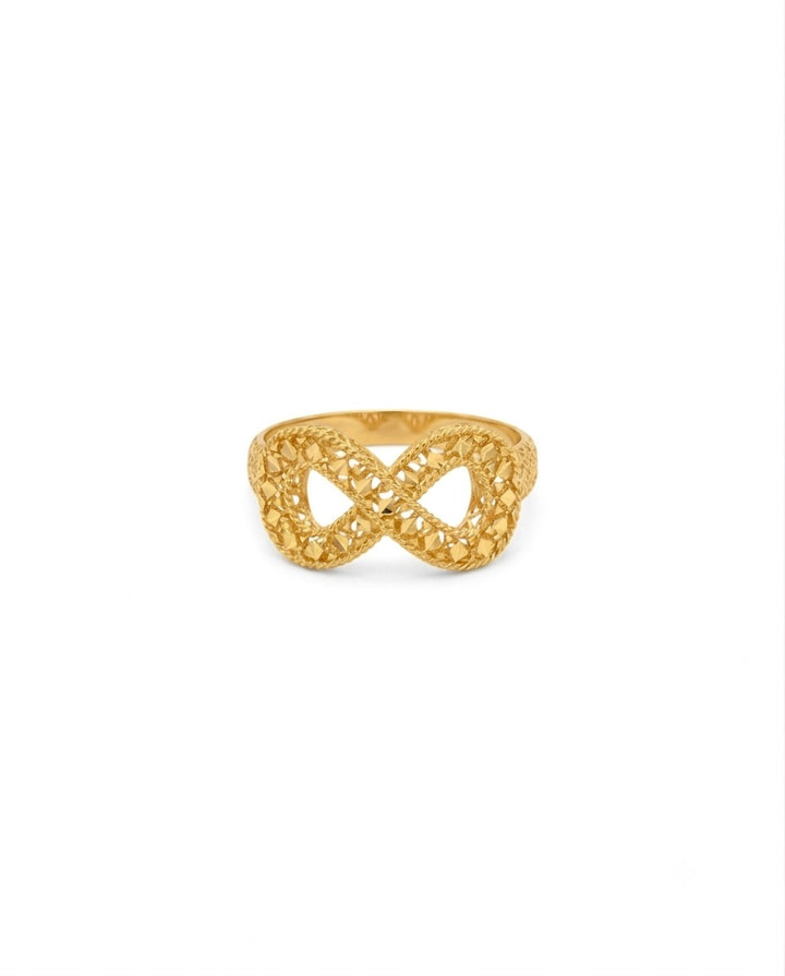Ring aus 18 Karat Gelbgold mit kunstvoller, durchbrochener Flechtstruktur. Das Design bildet eine elegante Unendlichkeitsform (∞) mit filigranen, diamantierten Oberflächen, die das Licht aus verschiedenen Winkeln reflektieren. Der Ring vereint moderne Eleganz mit traditioneller Goldschmiedekunst und wirkt zugleich leicht, luftig und luxuriös.