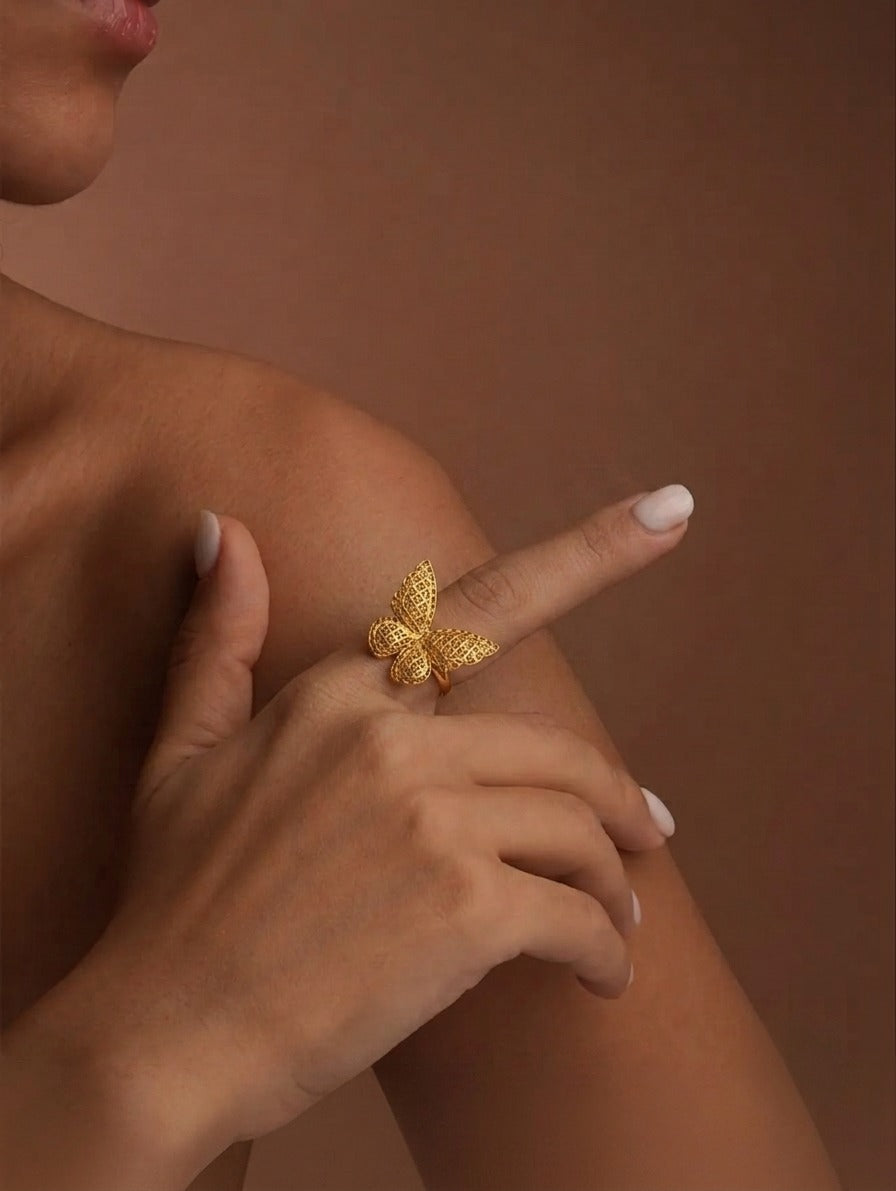 18 Karat Gelbgold Schmetterlingsring mit filigranem Cut-out-Design am Finger einer Frau getragen – eleganter Goldring mit detailreicher Schmetterlingsform als luxuriöser Blickfang.