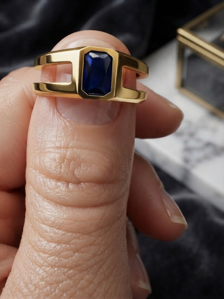 Geometrischer Goldring mit tiefblauem facettiertem Stein in Nahaufnahme