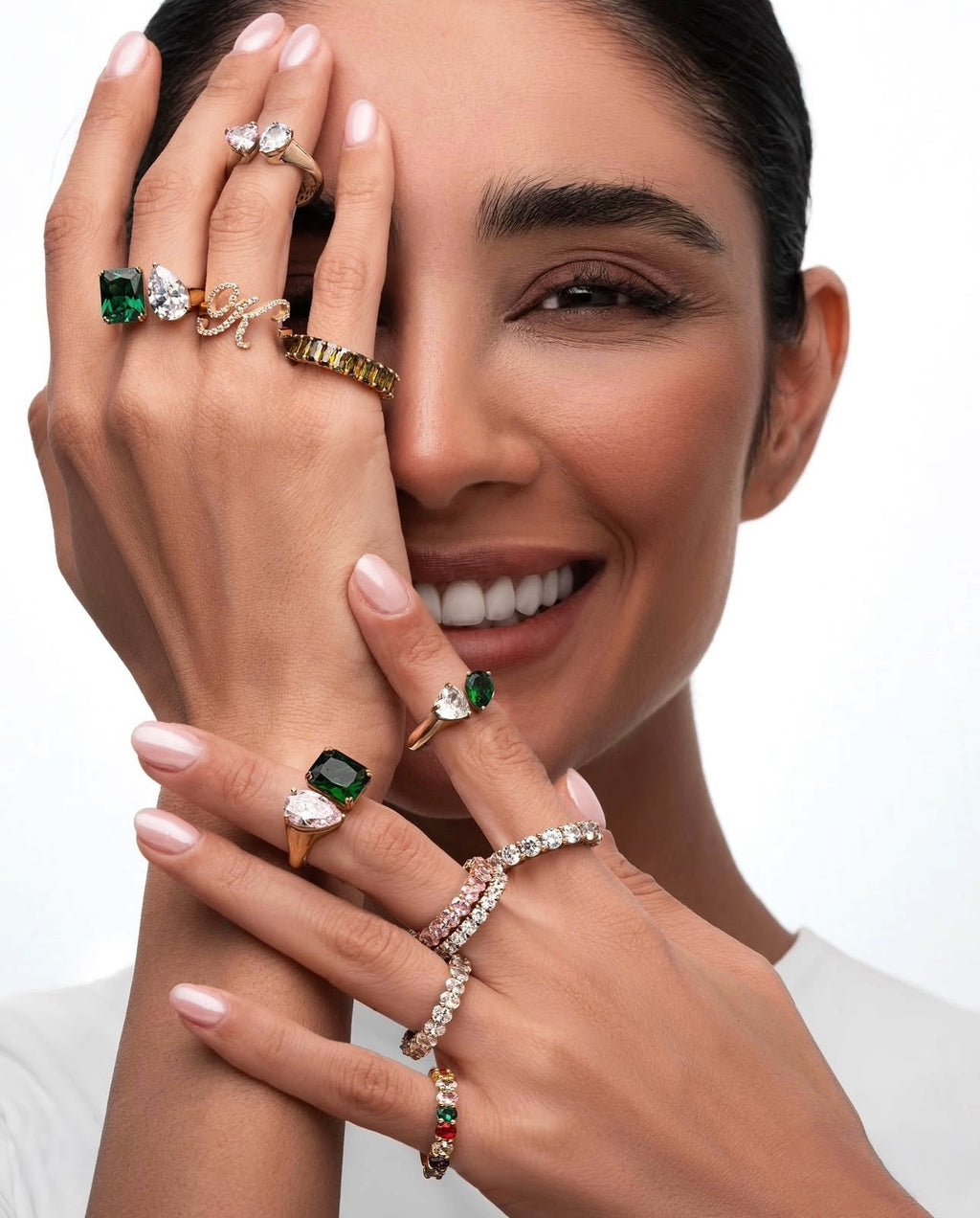 Nahaufnahme einer Frau, die mehrere Ringe trägt – darunter der Ring „Do Jān“ aus 18 Karat Gelbgold, gestaltet mit zwei funkelnden Steinen als Symbol für zwei Seelen, die miteinander verbunden sind.