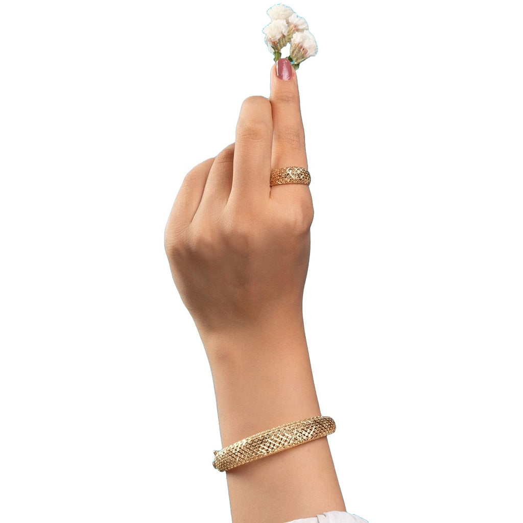 Hand mit einem floralen Arrangement, geschmückt mit dem Ring „Golbarg-e Pichideh“ aus 18 Karat Gelbgold – detailreich verflochtenes Blütenmuster, das Eleganz und Handwerkskunst vereint.