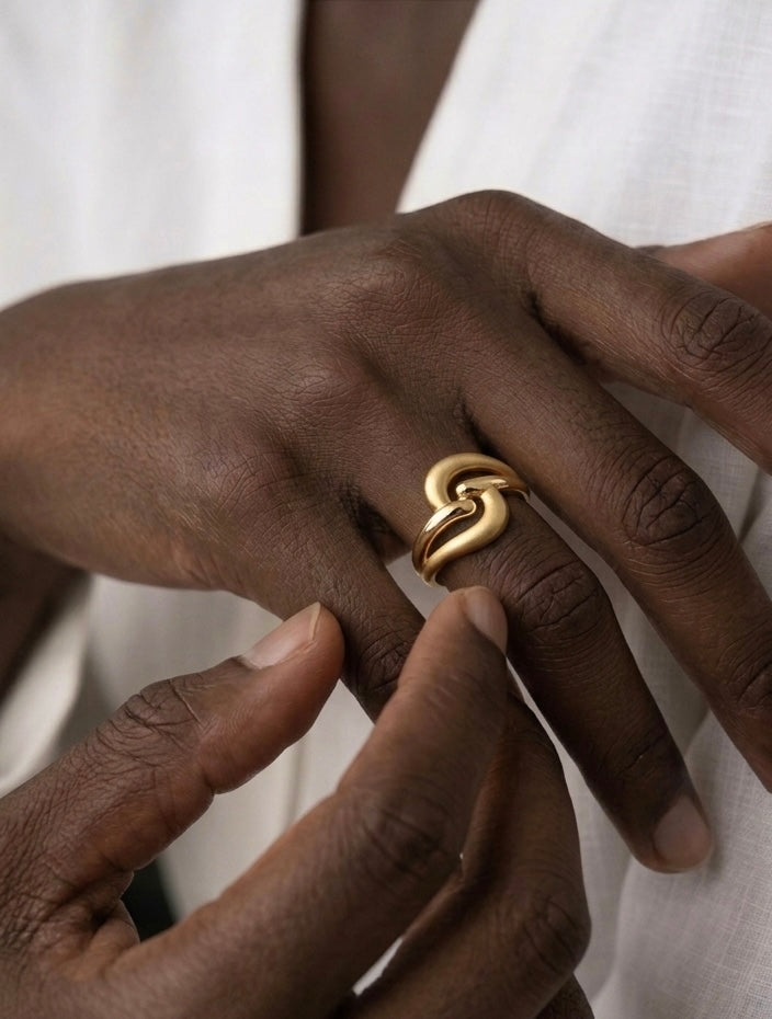Goldring aus 18k Gelbgold mit skulpturalem Design und mattierten sowie polierten Oberflächen, getragen an der Hand.
