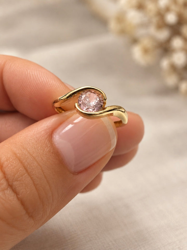 Detailansicht des Navazesh Rings mit geschwungenen Goldlinien und facettierter rosa Zirkonia