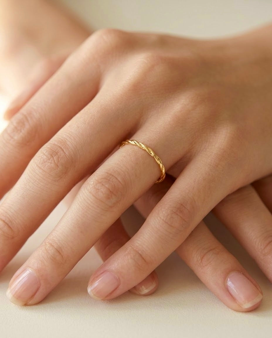 Filigraner Ring aus 18 Karat Gelbgold mit gedrehter Struktur, getragen an der Hand – eleganter minimalistischer Goldring.