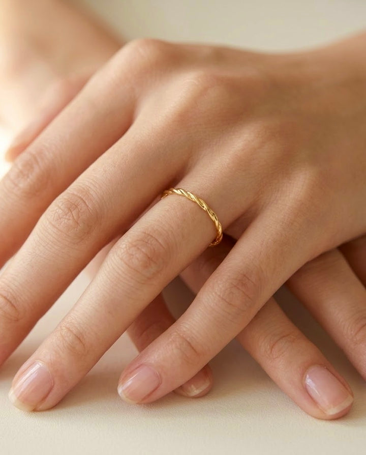 Filigraner Ring aus 18 Karat Gelbgold mit gedrehter Struktur, getragen an der Hand – eleganter minimalistischer Goldring.