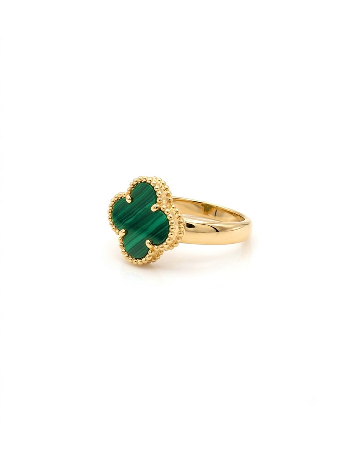 Detailaufnahme eines Goldrings mit grünem Malachit im Kleeblatt-Design