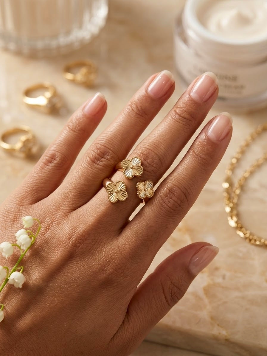 Handgefertigter Blütenring aus 18 Karat Gelbgold mit drei filigranen Blüten, getragen an der Hand