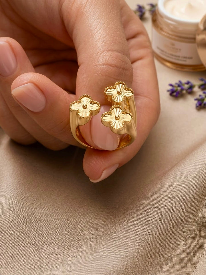 Detailaufnahme eines handgefertigten Blütenrings aus 18 Karat Gelbgold mit drei filigran gravierten Goldblüten