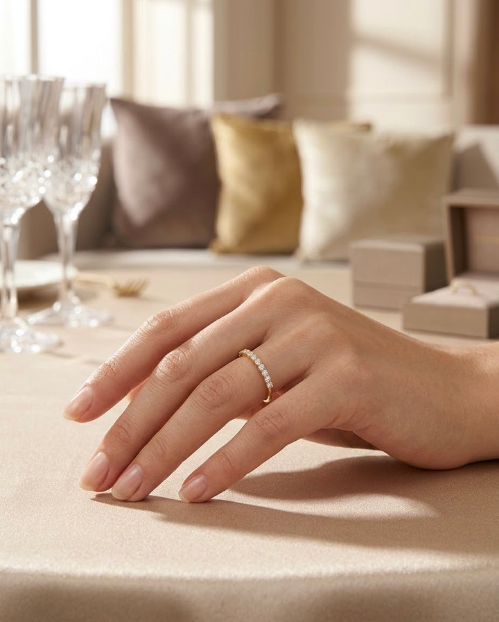 Eleganter Damenring aus 18 Karat Gelbgold mit funkelnden weissen Zirkonia, getragen an einer Hand vor edlem, warmem Interieur.