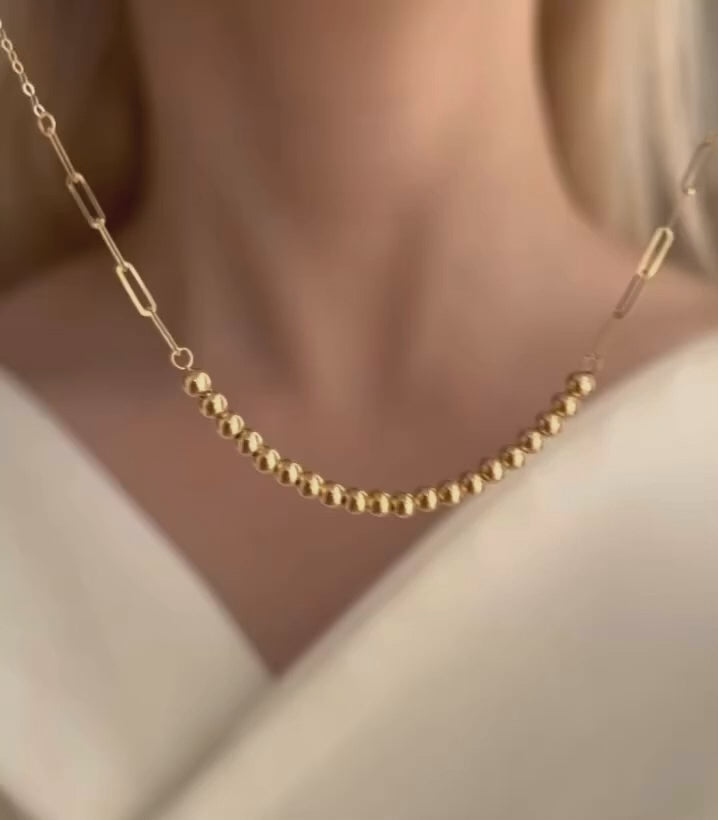 Videoaufnahme der Zanjir Tala-e Morvarid – Goldperlenkette wird spielerisch aus verschiedenen Perspektiven gezeigt, vor und am Hals eines Models mit heller Haut